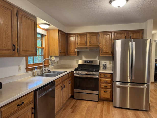 52 Jericho Rd, Grantham, NH 03753 - kitchen with stainless steel appliances, under cabinet range hood, a sink, brown cabinets, and light countertops