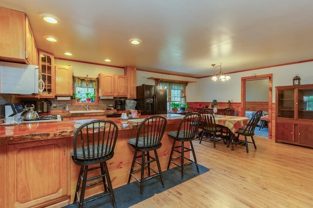 101 Mudgett Hill Rd, Loudon, NH 03307 - kitchen featuring black refrigerator with ice dispenser, white microwave, a sink, glass insert cabinets, and wainscoting