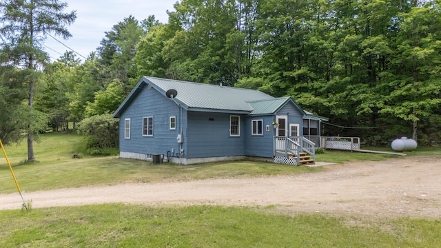 101 Mudgett Hill Rd, Loudon, NH 03307 - view of front of house with dirt driveway, a front yard, metal roof, and a deck