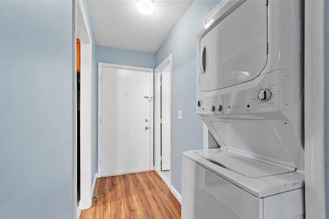 310 Brook Village Rd Unit 26, Nashua, NH 03062 - laundry area with stacked washer / drying machine, light wood-type flooring, and a textured ceiling