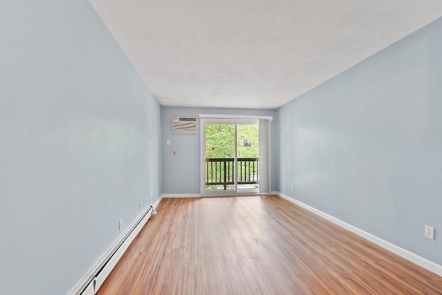 310 Brook Village Rd Unit 26, Nashua, NH 03062 - unfurnished room featuring wood finished floors, baseboards, baseboard heating, and a wall mounted AC