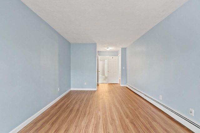 310 Brook Village Rd Unit 26, Nashua, NH 03062 - empty room featuring a baseboard heating unit, light wood finished floors, and baseboards