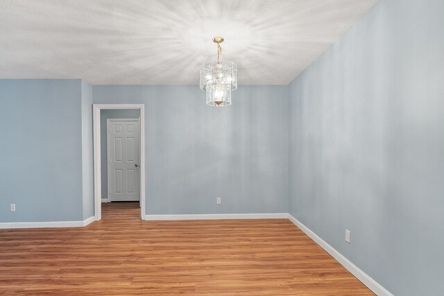 310 Brook Village Rd Unit 26, Nashua, NH 03062 - empty room with light wood-style floors, a chandelier, and baseboards