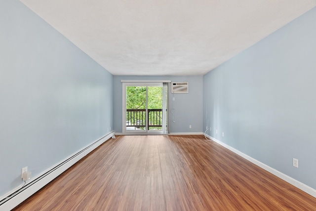 310 Brook Village Rd Unit 26, Nashua, NH 03062 - spare room with a baseboard heating unit, wood finished floors, an AC wall unit, and baseboards
