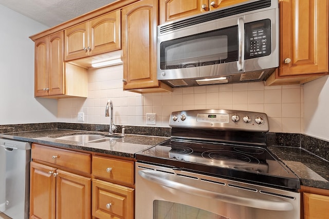 310 Brook Village Rd Unit 26, Nashua, NH 03062 - kitchen featuring stainless steel appliances, a sink, backsplash, and dark stone countertops