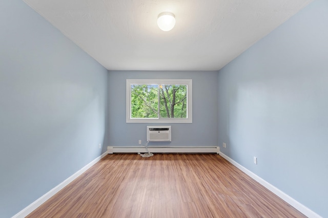 310 Brook Village Rd Unit 26, Nashua, NH 03062 - unfurnished room featuring wood finished floors, baseboards, an AC wall unit, and a baseboard heating unit