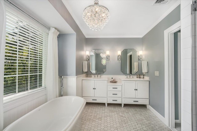 373 Whitford St, Manchester, NH 03104 - full bath with a freestanding tub, double vanity, a chandelier, ornamental molding, and tile patterned floors