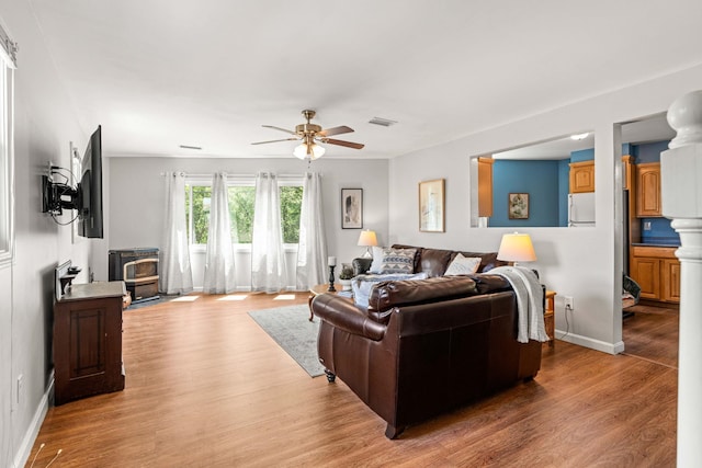 19 Fowlers Ct, Seabrook, NH 03874 - living area featuring a wood stove, ceiling fan, light wood-style flooring, and baseboards