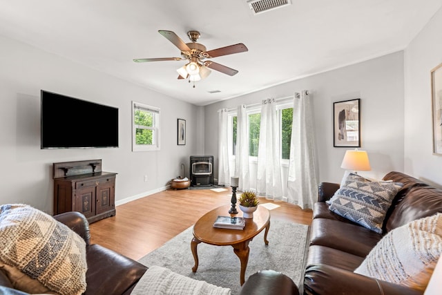 19 Fowlers Ct, Seabrook, NH 03874 - living room with a wood stove, a ceiling fan, wood finished floors, and baseboards