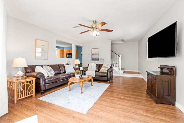 19 Fowlers Ct, Seabrook, NH 03874 - living room with stairway, ceiling fan, light wood-style flooring, and baseboards