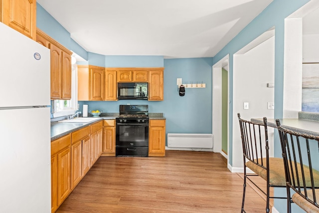 19 Fowlers Ct, Seabrook, NH 03874 - kitchen featuring gas stove, black microwave, freestanding refrigerator, a baseboard heating unit, and a sink
