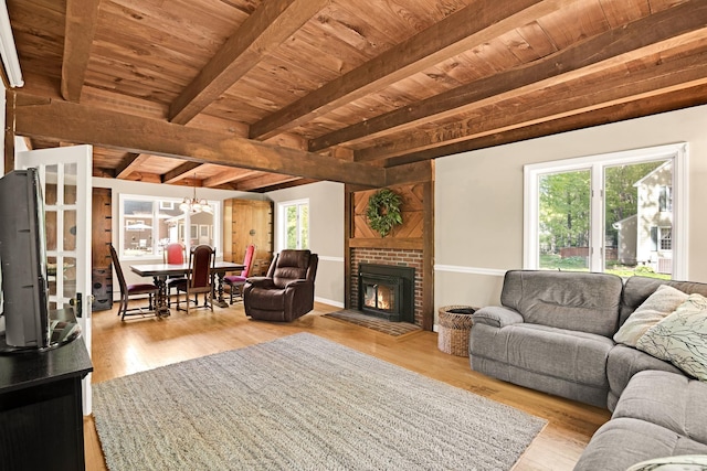 23 Cedarview Ln, Hampton, NH 03842 - living area with wooden ceiling with exposed beams, healthy amount of natural light, wood finished floors, and a fireplace