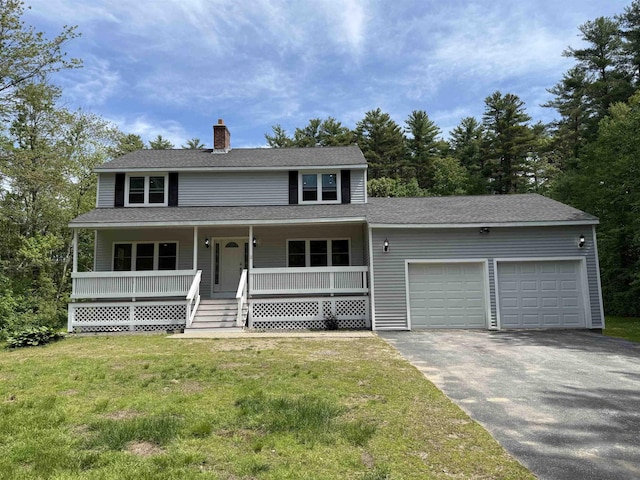 2 Germantown Rd, Derry, NH 03038 - view of front of home with a garage, driveway, a chimney, a front yard, and a porch