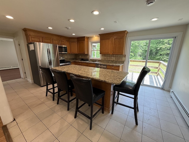 2 Germantown Rd, Derry, NH 03038 - kitchen with appliances with stainless steel finishes, a baseboard heating unit, tasteful backsplash, a kitchen breakfast bar, and recessed lighting