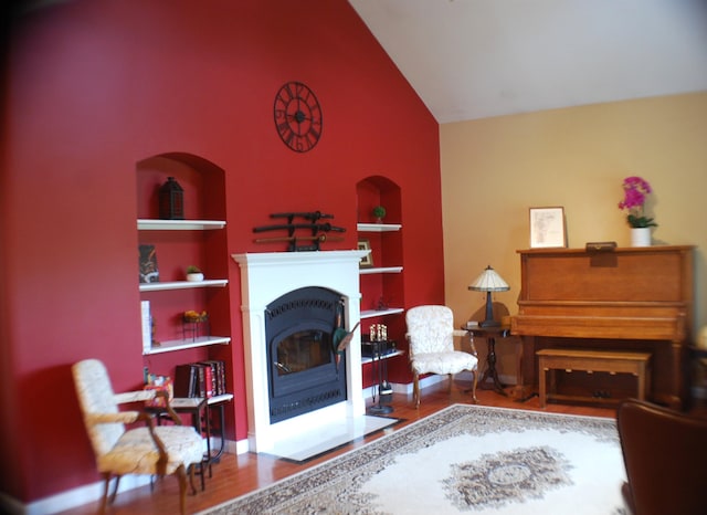 190 Decker Rd, Georgia, VT 05468 - living room with built in features, high vaulted ceiling, a fireplace with flush hearth, and wood finished floors