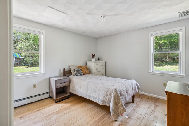 24 Theresa Ave, Salem, NH 03079 - bedroom featuring a baseboard radiator, multiple windows, light wood-style flooring, and baseboards
