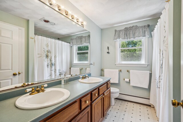 24 Theresa Ave, Salem, NH 03079 - bathroom with a baseboard radiator, double vanity, tile patterned floors, toilet, and a shower with curtain