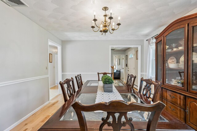 24 Theresa Ave, Salem, NH 03079 - dining room featuring a chandelier, wood finished floors, baseboards, and a baseboard heating unit