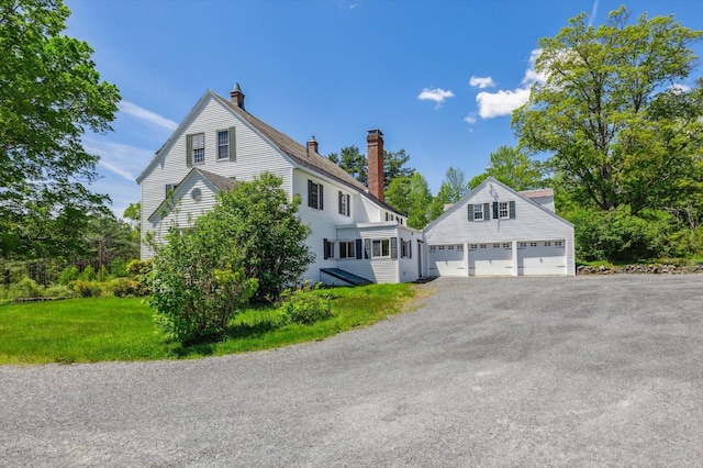 236 Main St, Jaffrey, NH 03452 - view of side of property with a chimney, a garage, and driveway