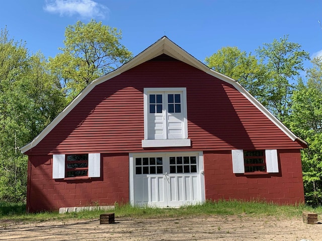 236 Main St, Jaffrey, NH 03452 - view of property exterior featuring a garage, a gambrel roof, concrete block siding, and a barn