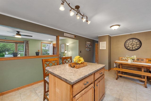 6 Cherry St, Concord, NH 03301 - kitchen with light tile patterned floors, a center island, baseboards, a ceiling fan, and crown molding