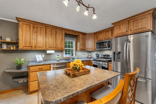 6 Cherry St, Concord, NH 03301 - kitchen with appliances with stainless steel finishes, brown cabinets, a kitchen breakfast bar, a sink, and a kitchen island