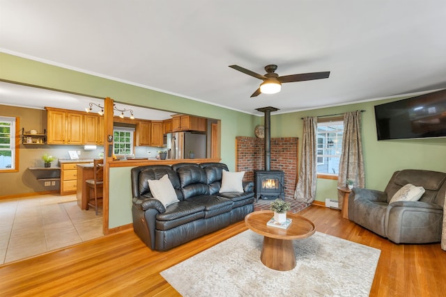 6 Cherry St, Concord, NH 03301 - living room featuring a wood stove, healthy amount of natural light, a ceiling fan, light wood finished floors, and ornamental molding