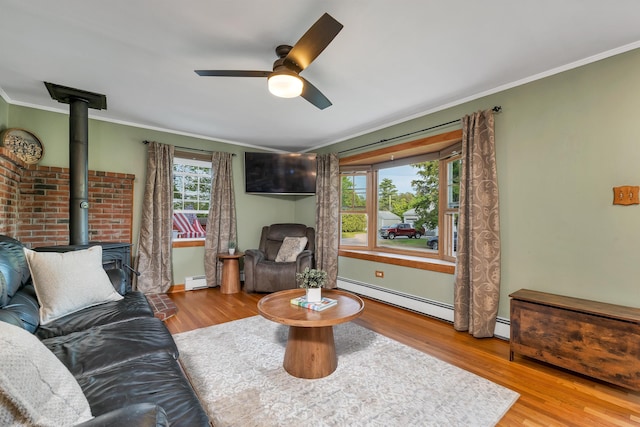 6 Cherry St, Concord, NH 03301 - living area with a baseboard radiator, a wood stove, ornamental molding, a ceiling fan, and wood finished floors