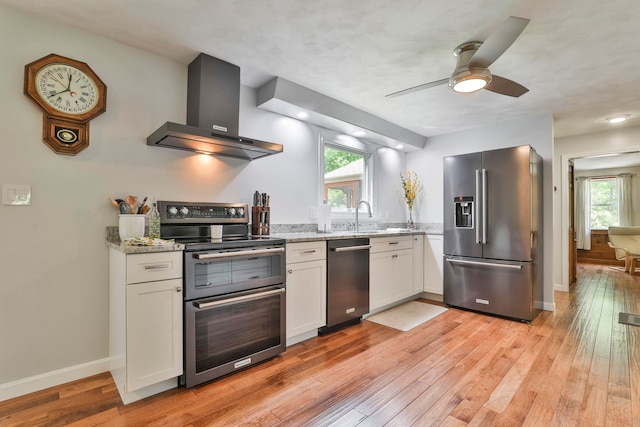 56 Averill Rd, Brookline, NH 03033 - kitchen with appliances with stainless steel finishes, wall chimney exhaust hood, white cabinets, and light stone countertops