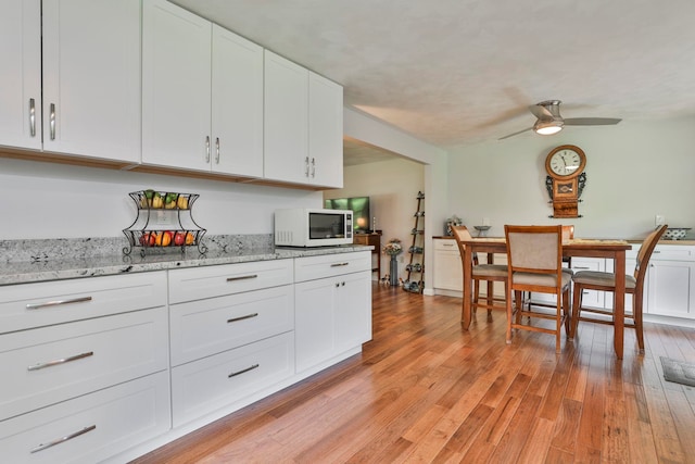 56 Averill Rd, Brookline, NH 03033 - kitchen with white microwave, white cabinets, ceiling fan, and light wood-style floors