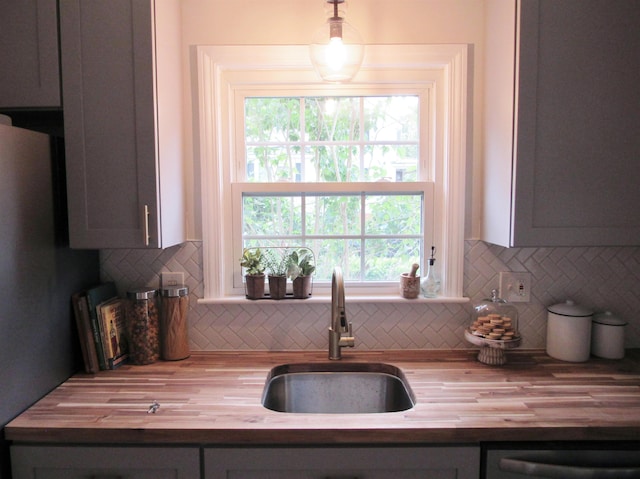 798 Hanover St, Manchester, NH 03104 - kitchen featuring wooden counters, a sink, backsplash, and hanging light fixtures