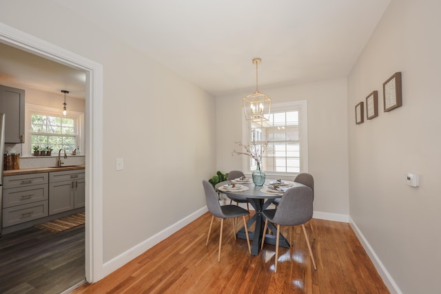 798 Hanover St, Manchester, NH 03104 - dining room featuring a chandelier, wood finished floors, and baseboards