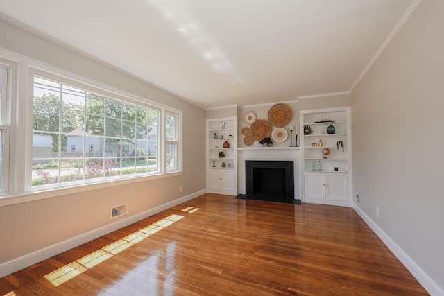 798 Hanover St, Manchester, NH 03104 - unfurnished living room with wood finished floors, a fireplace with flush hearth, baseboards, built in shelves, and ornamental molding