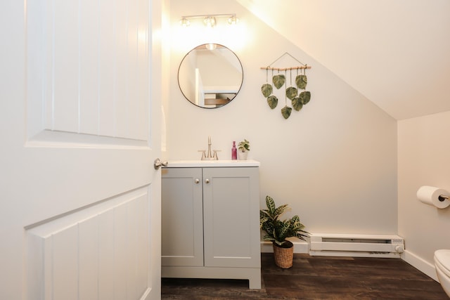 798 Hanover St, Manchester, NH 03104 - half bath featuring baseboard heating, toilet, vanity, wood finished floors, and baseboards
