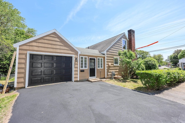 798 Hanover St, Manchester, NH 03104 - view of front of property featuring a chimney, a garage, asphalt driveway, and entry steps
