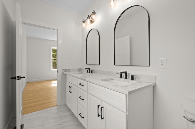 93 Stage Rd, Hampstead, NH 03841 - bathroom with marble look tile flooring, double vanity, baseboards, and toilet