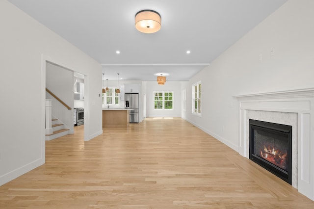 93 Stage Rd, Hampstead, NH 03841 - unfurnished living room with a glass covered fireplace, stairs, light wood-style flooring, baseboards, and recessed lighting