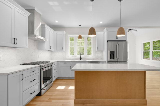 93 Stage Rd, Hampstead, NH 03841 - kitchen featuring appliances with stainless steel finishes, wall chimney exhaust hood, plenty of natural light, light wood finished floors, and recessed lighting