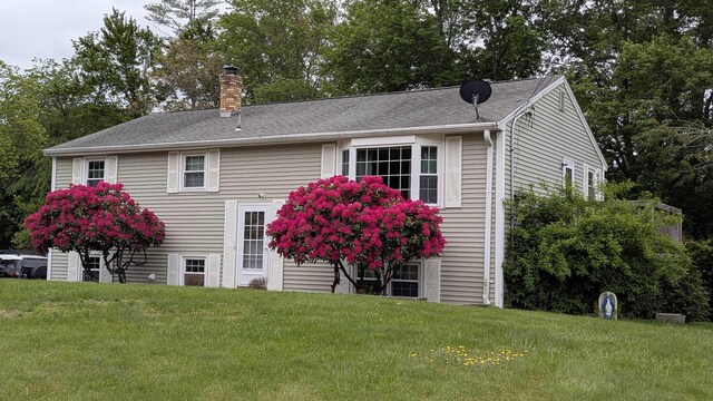 19 Bradford Dr, Salem, NH 03079 - view of front of property featuring a chimney, a front yard, and view of scattered trees