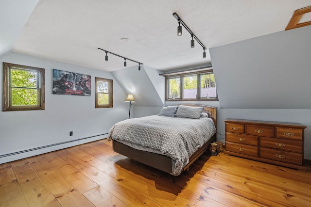 126 Stoddard Rd, Columbia, NH 03576 - bedroom with rail lighting, light wood-type flooring, a baseboard heating unit, multiple windows, and lofted ceiling