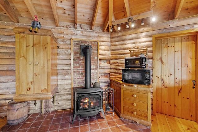 126 Stoddard Rd, Columbia, NH 03576 - detailed view of a wood stove, wood ceiling with exposed beams, log walls, and black microwave