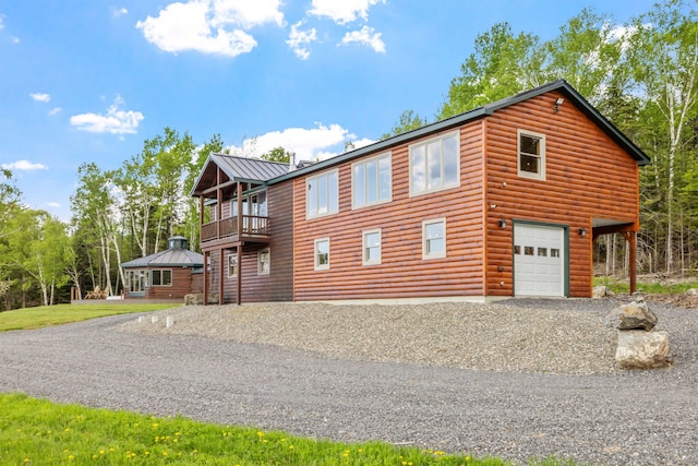 126 Stoddard Rd, Columbia, NH 03576 - view of front facade featuring a balcony, driveway, log veneer siding, and metal roof