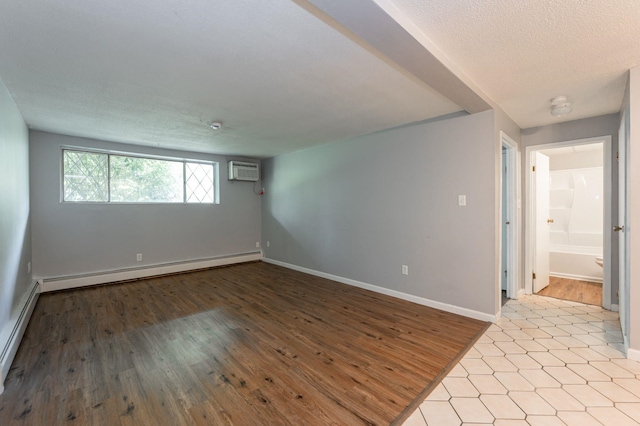 17 Silvestri Cir Unit 4, Derry, NH 03038 - spare room with an AC wall unit, baseboard heating, wood finished floors, baseboards, and a textured ceiling
