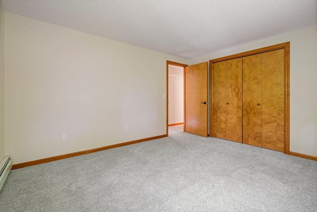 40 Trolley St, Manchester, NH 03103 - unfurnished bedroom with carpet floors, baseboards, a closet, and a baseboard radiator