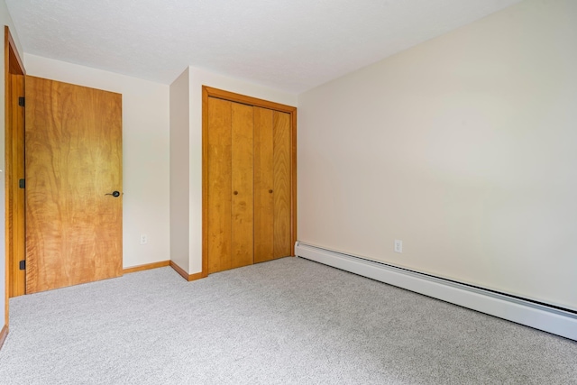 40 Trolley St, Manchester, NH 03103 - unfurnished bedroom featuring baseboard heating, a closet, carpet flooring, and baseboards