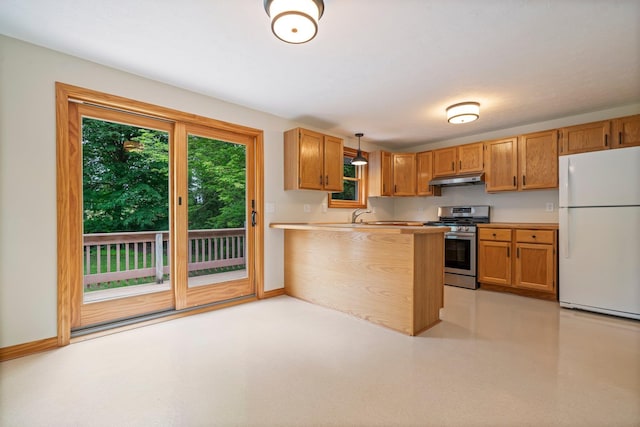40 Trolley St, Manchester, NH 03103 - kitchen featuring freestanding refrigerator, stainless steel range with gas cooktop, under cabinet range hood, baseboards, and a peninsula