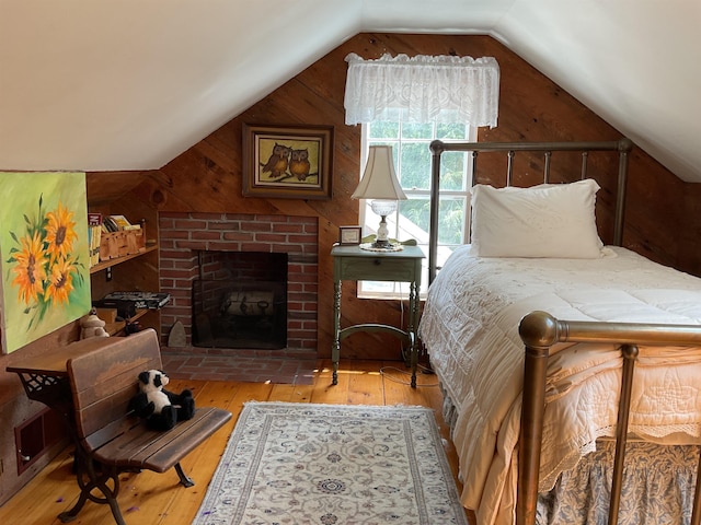 2 Mack Hill Rd, Amherst, NH 03031 - bedroom with vaulted ceiling, hardwood / wood-style flooring, wood walls, and a brick fireplace