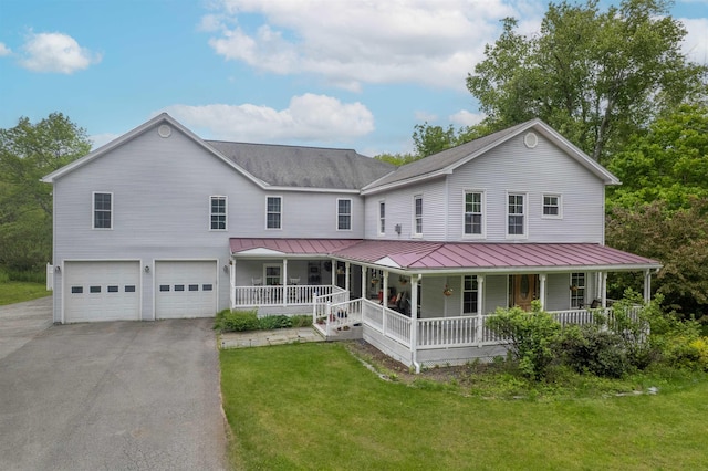 1851 York Street Ext, Poultney, VT 05764 - farmhouse with a porch, asphalt driveway, an attached garage, a front yard, and a standing seam roof