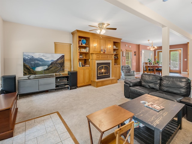 1851 York Street Ext, Poultney, VT 05764 - living room with light carpet, a ceiling fan, a warm lit fireplace, a chandelier, and light tile patterned floors