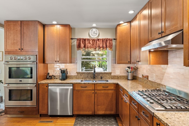 165 Tanglewood Dr, Colchester, VT 05546 - kitchen featuring appliances with stainless steel finishes, under cabinet range hood, a sink, light stone counters, and recessed lighting